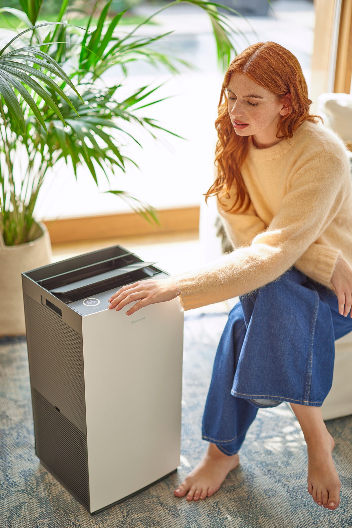 Woman adjusting settings on a modern air purifier