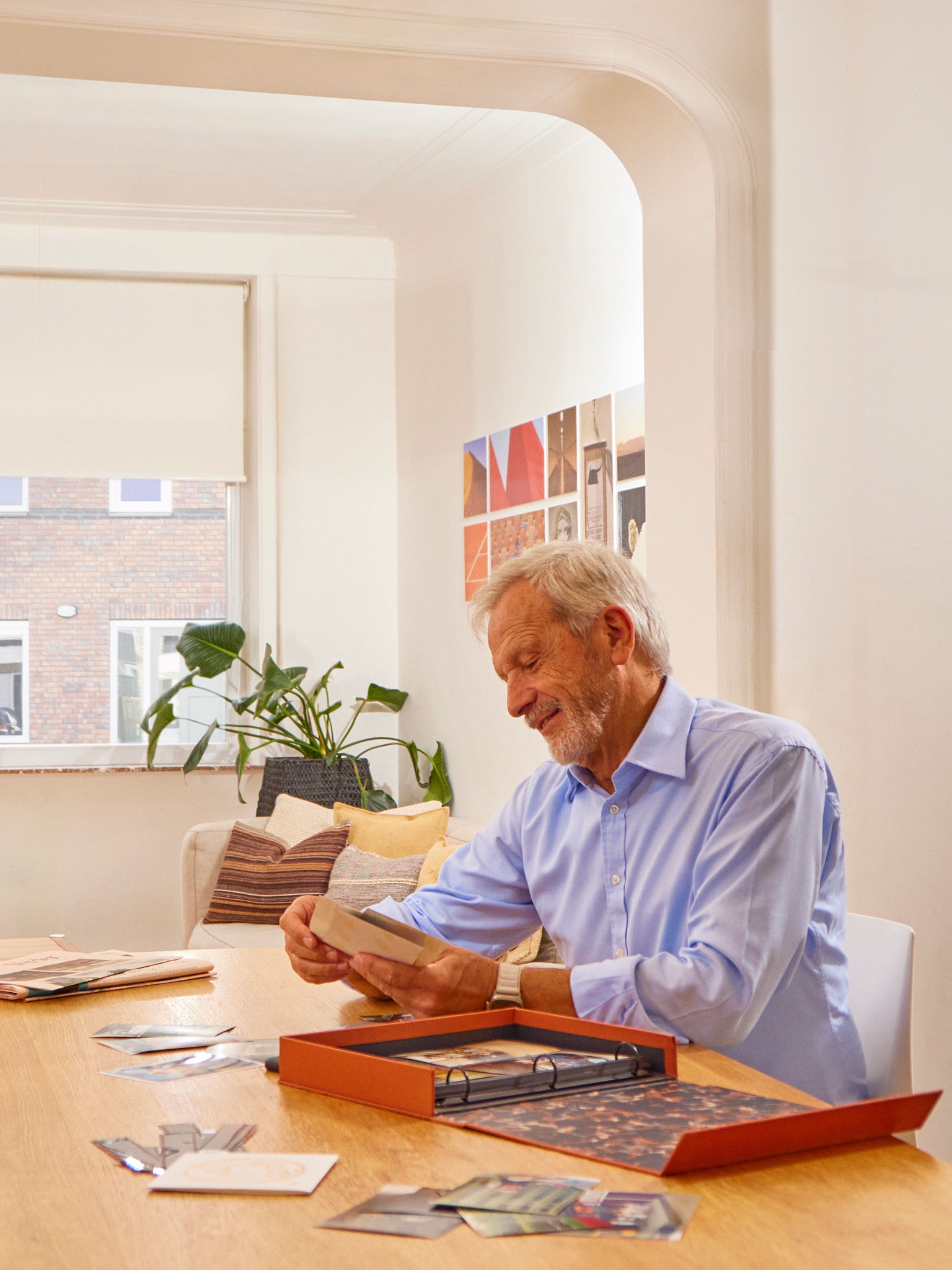 Man at table with photo album in dry, healthy living room thanks to moisture-controlling ventilation