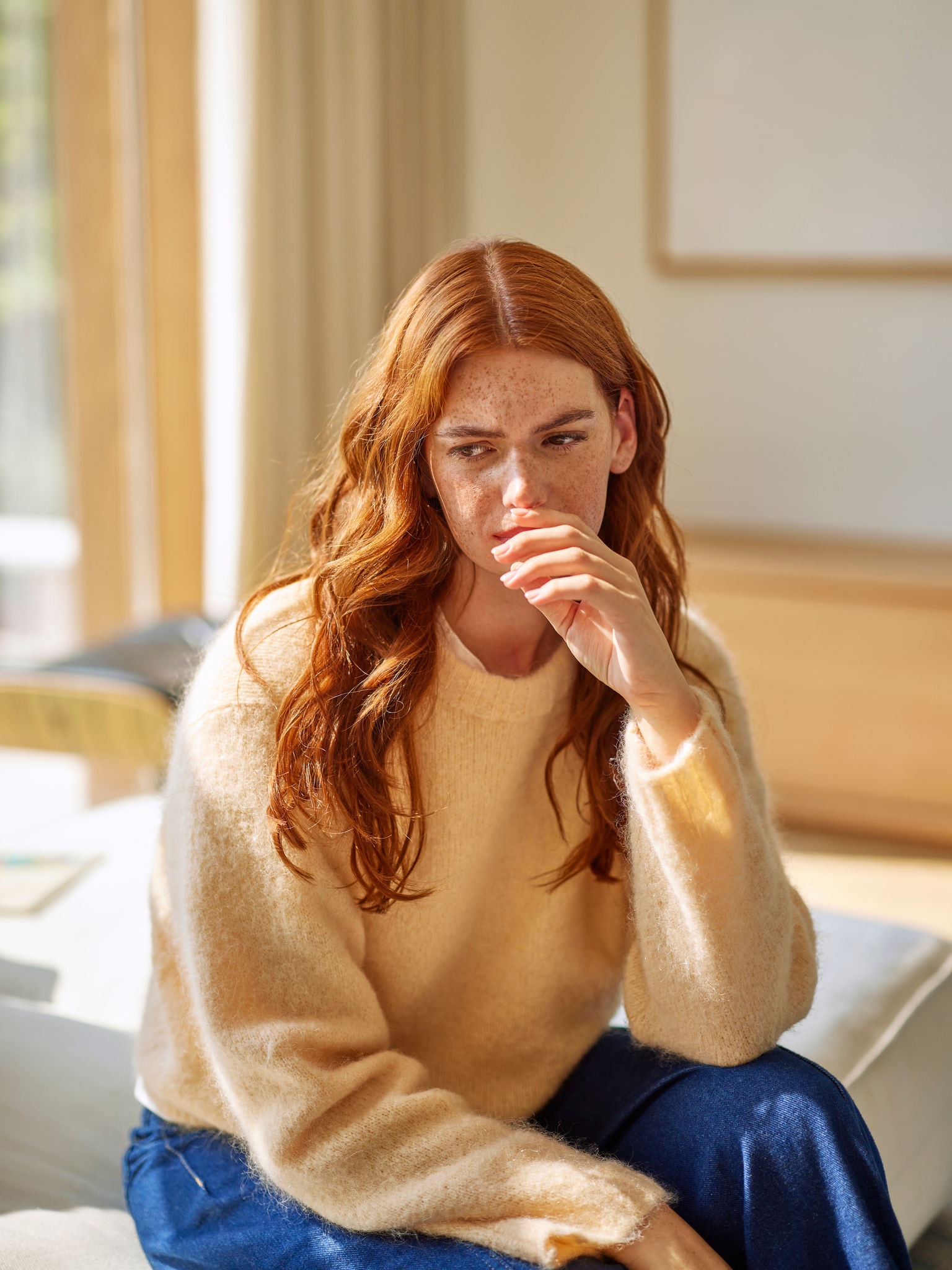 Woman reacting to unpleasant cooking odours in living room