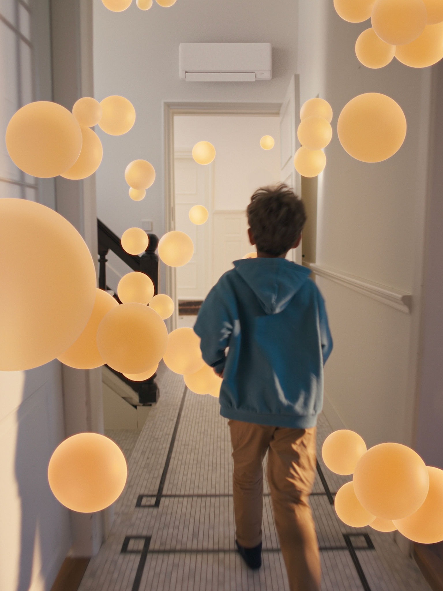 Boy walking through a hallway with consistent, balanced airflow, made possible by a well-designed air-to-air heat pump system