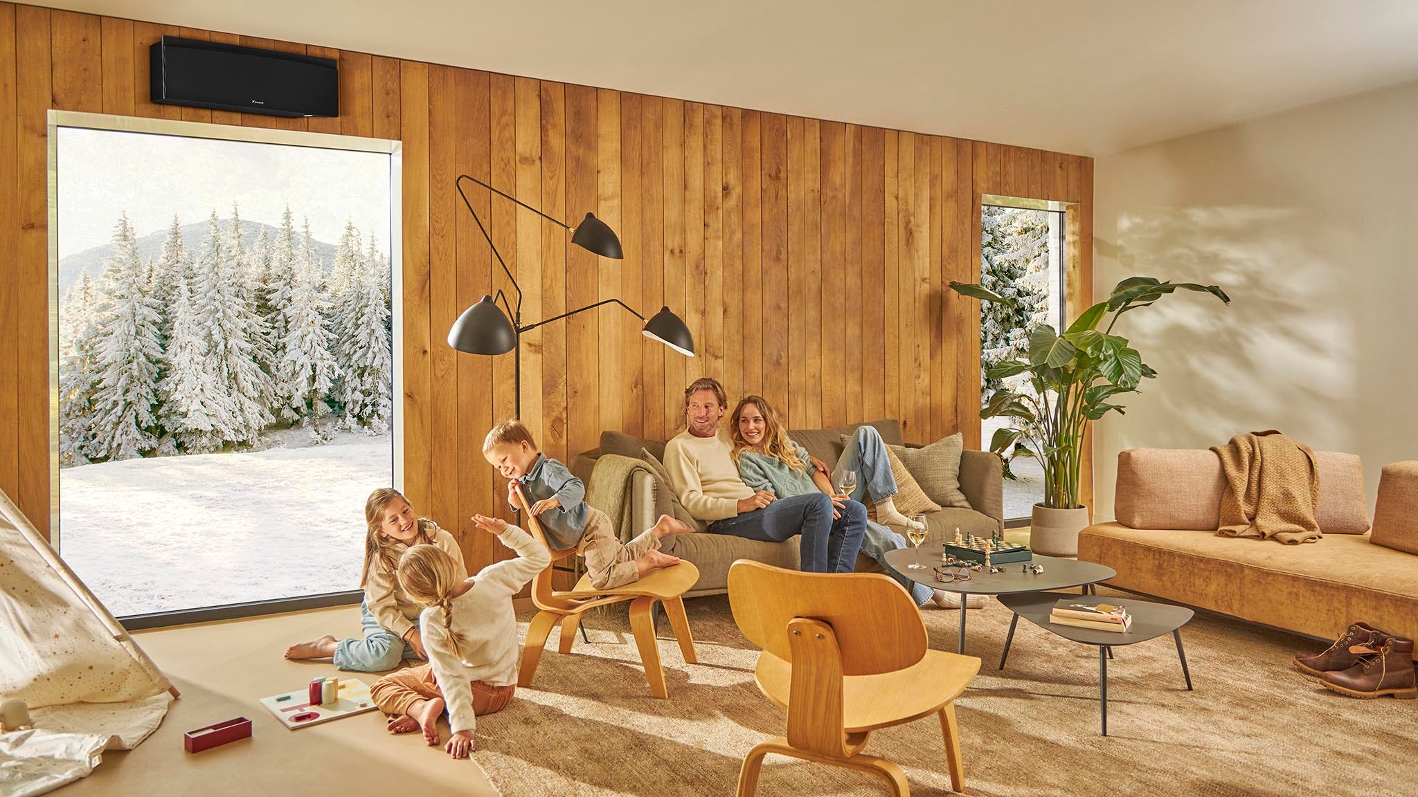 Family of four laughing while playing a board game in their ventilated kitchen