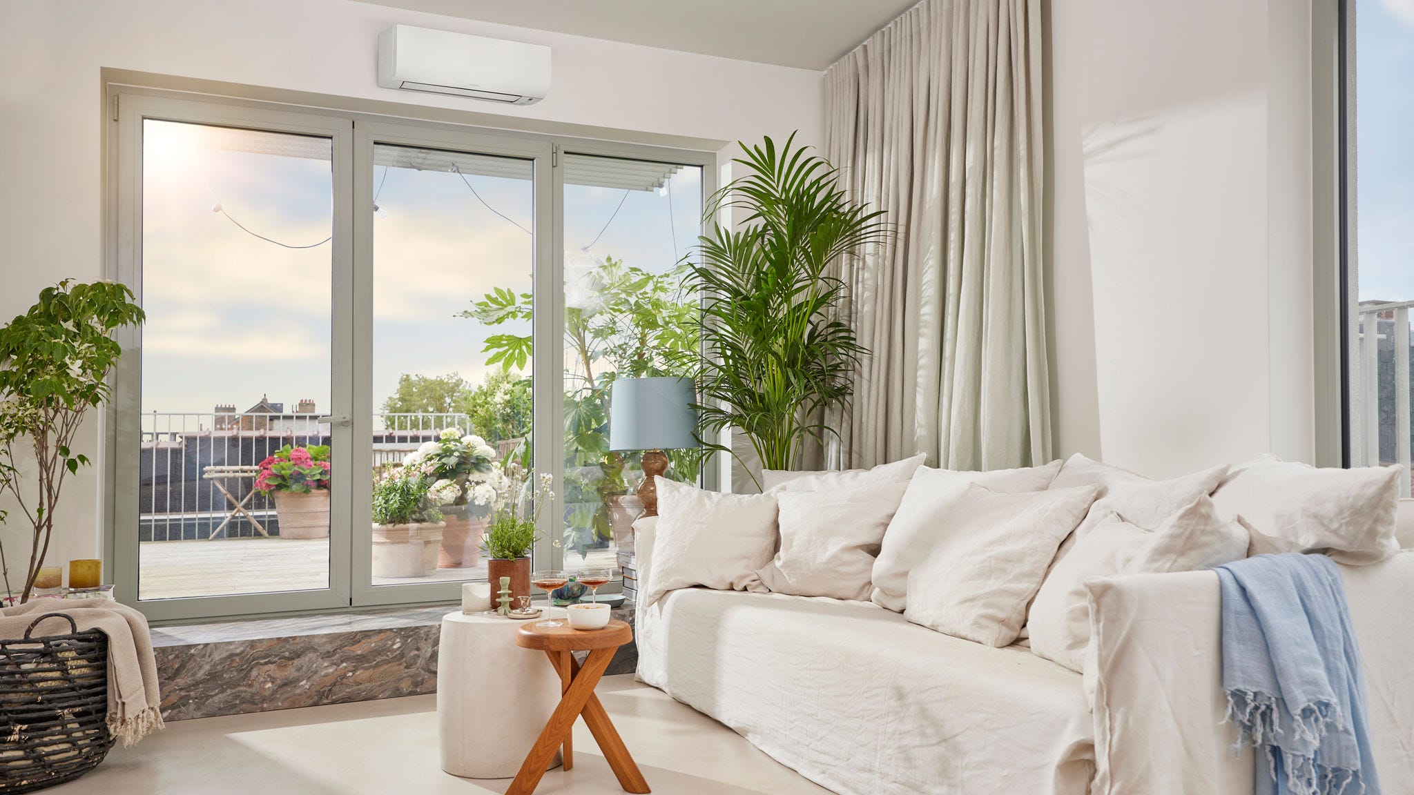 A bright, airy room with a discreet white, wall-mounted air-to-air heat pump being both heated and cooled