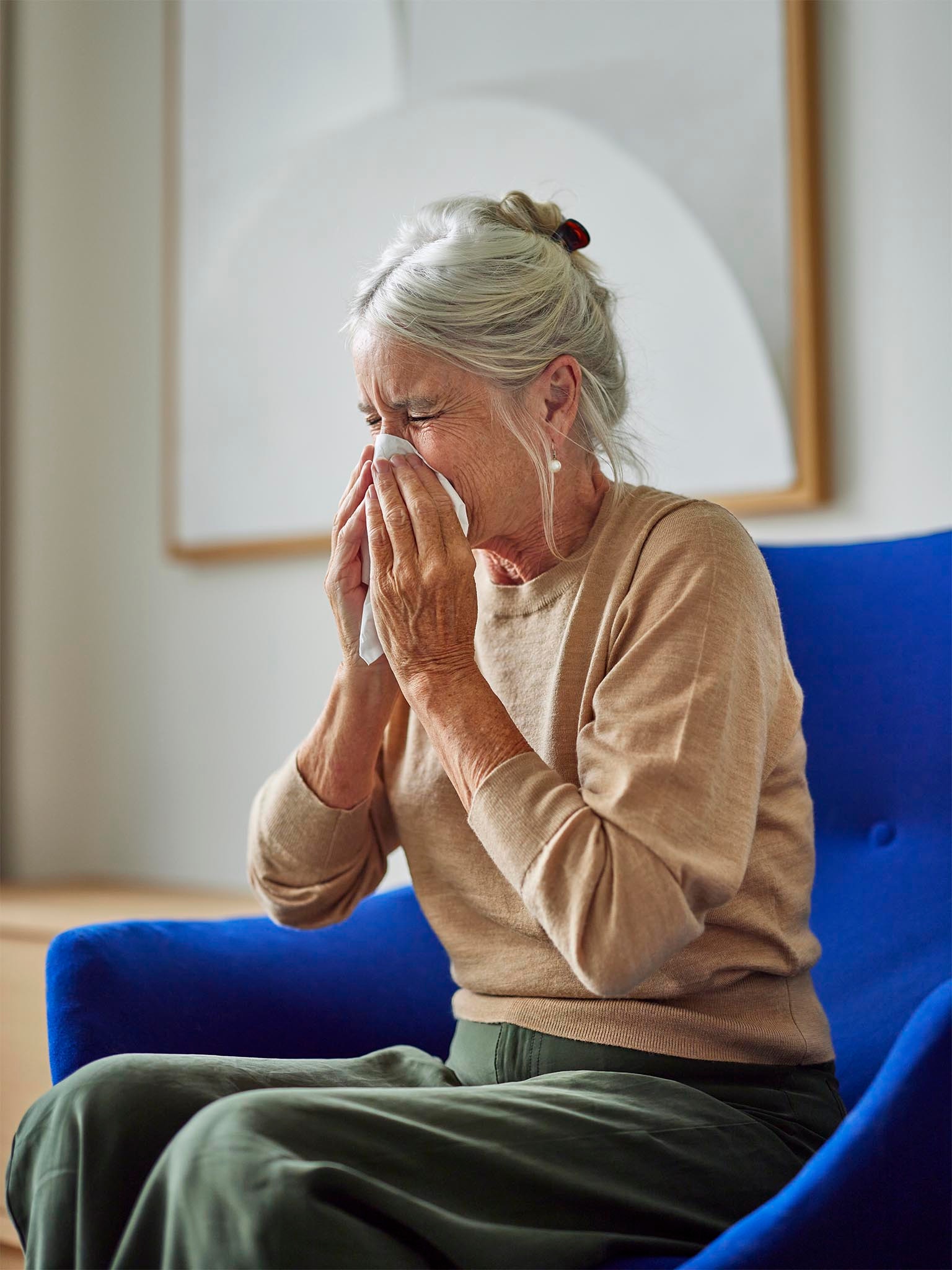 Woman sneezing because of allergies