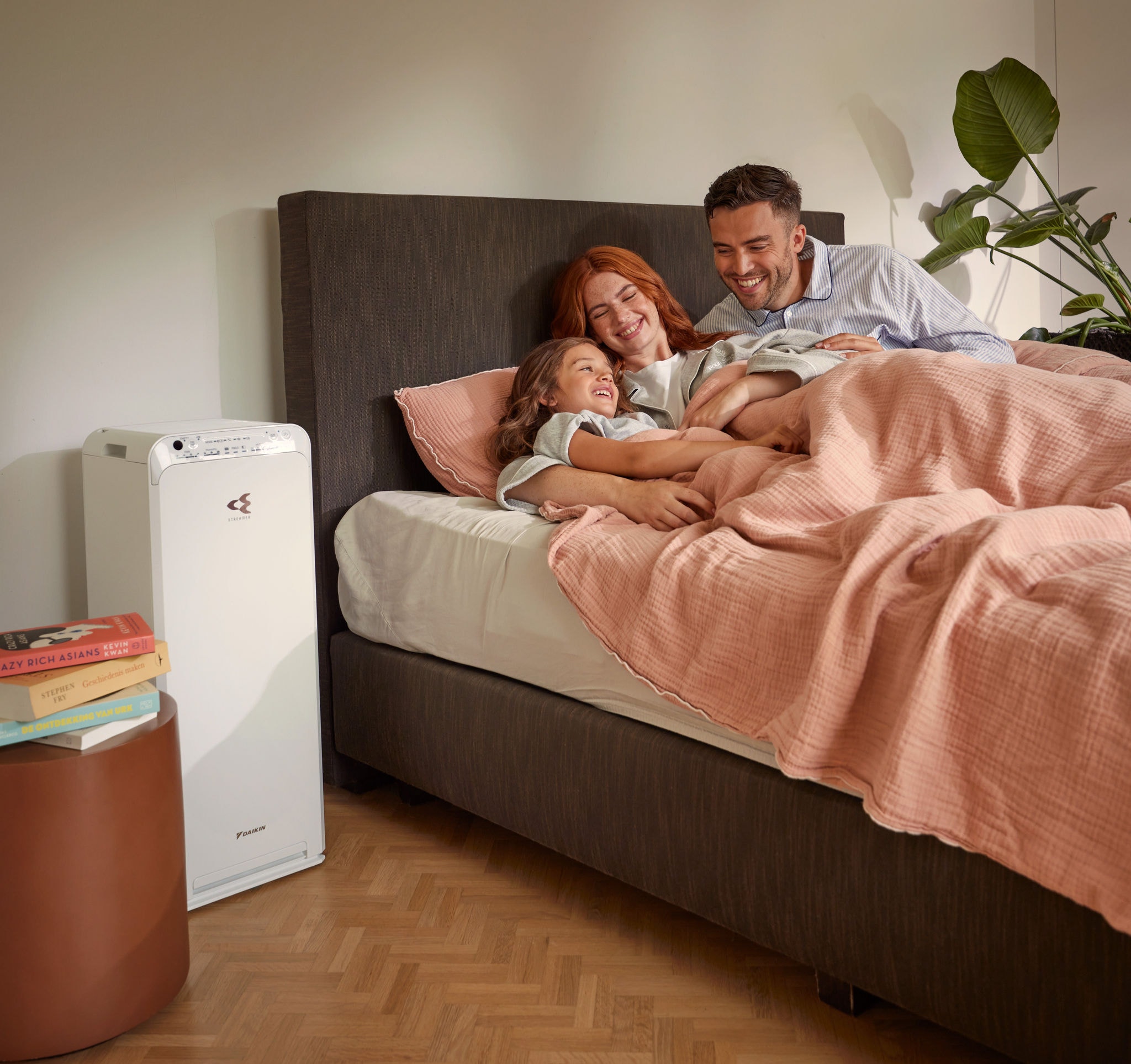 Couple with kid relaxing in bedroom enjoying clean air with air purifier