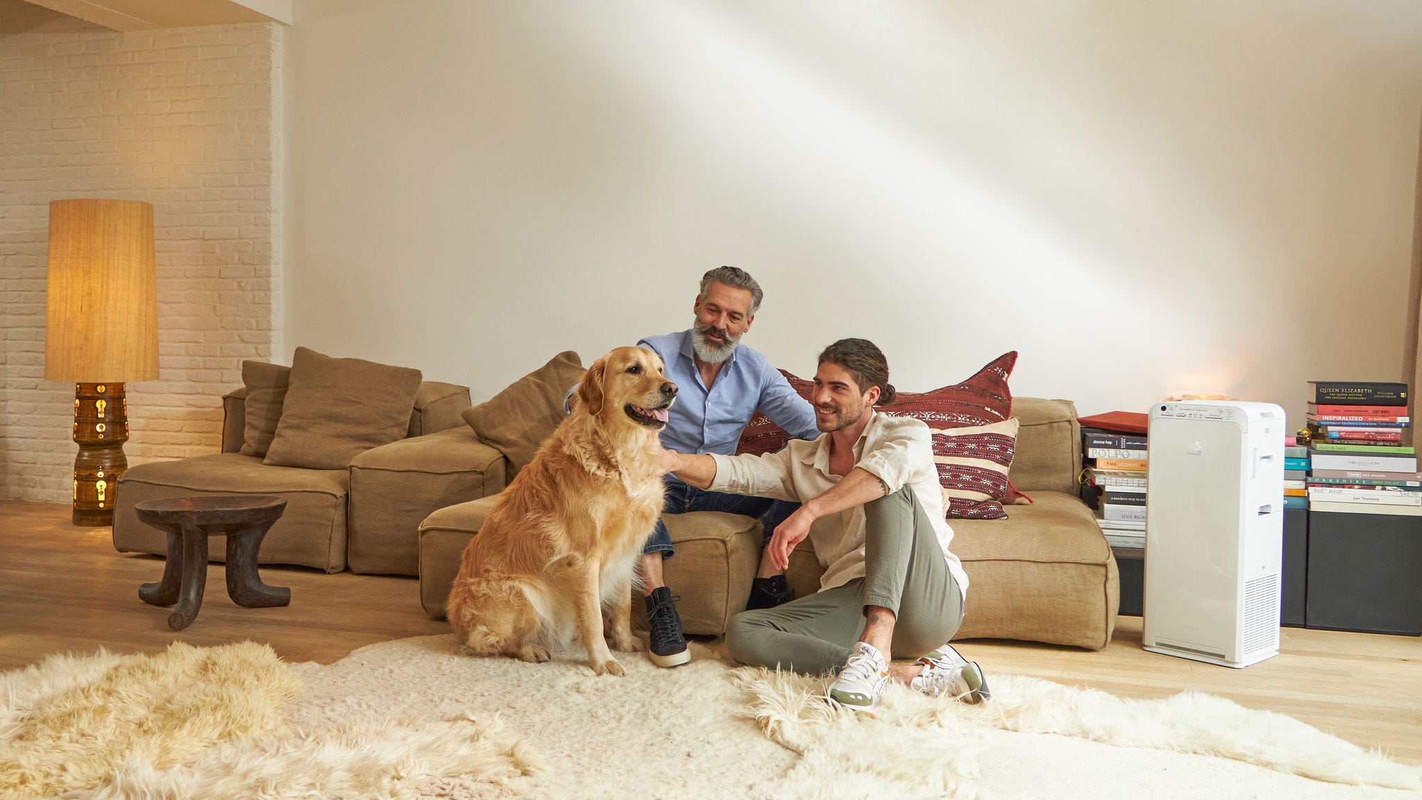 Father and son petting their dog not worried about pet hair thanks to the air purifier