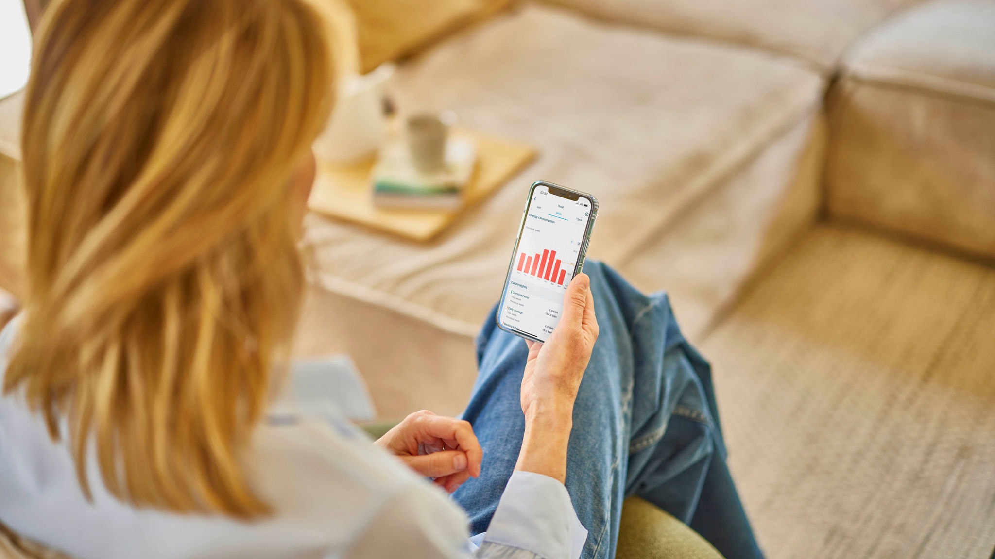 Woman controlling her ventilation unit using the Onecta app