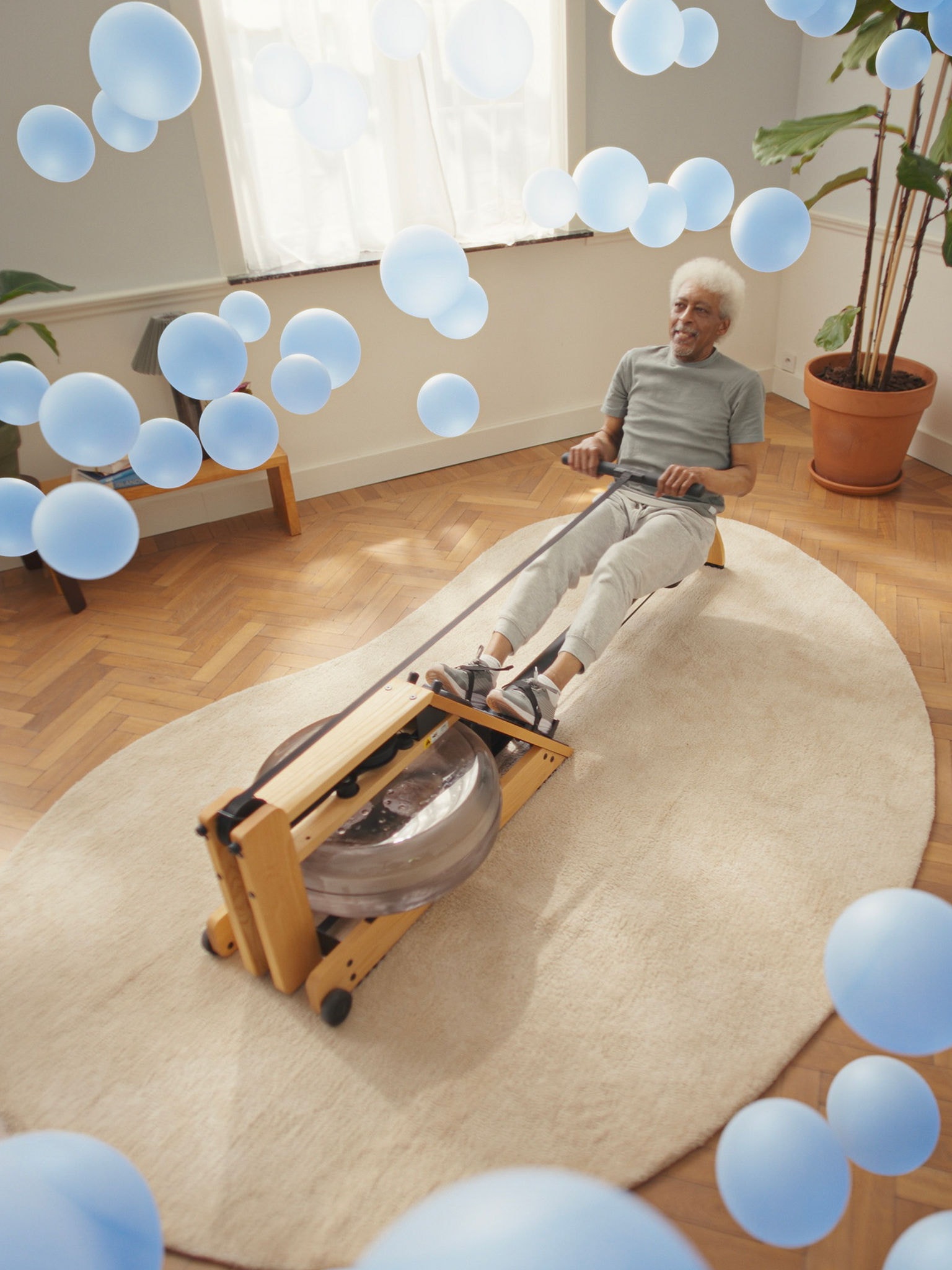 Older man working out on a rowing machine in a perfectly climate-controlled room, thanks to responsive air-to-air heat pump technology