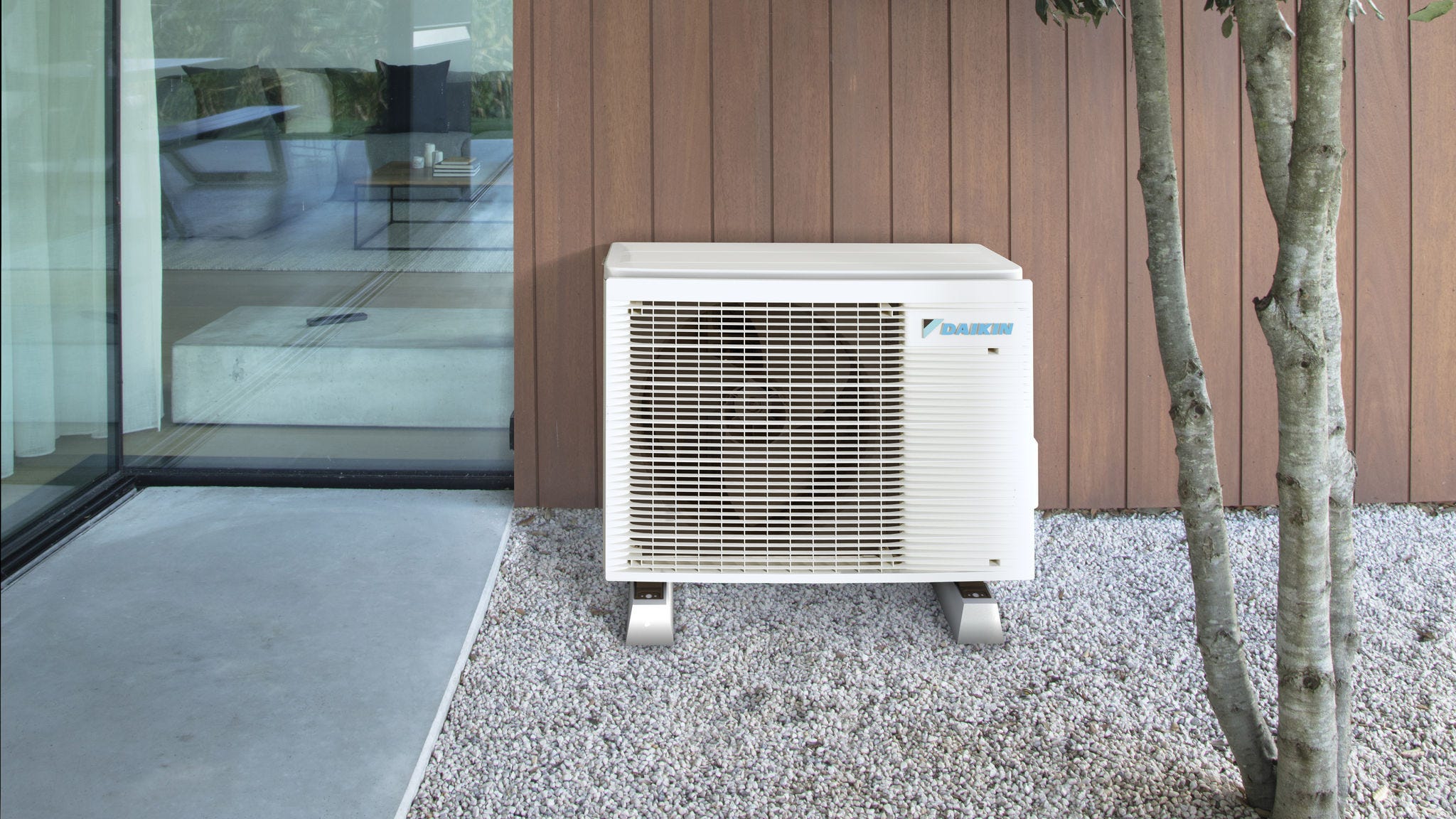 Compact air source heat pump installed discreetly outside beside a modern home