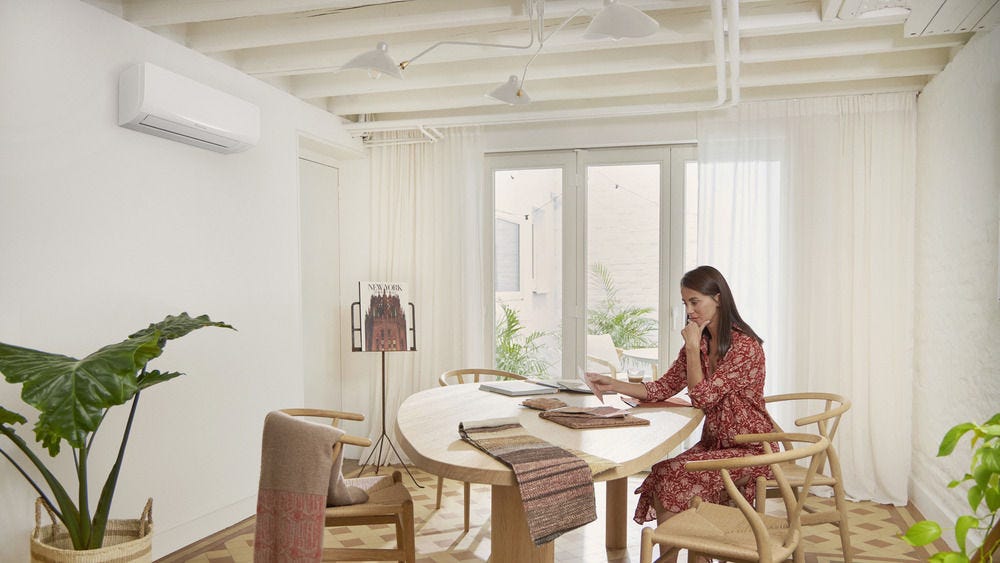 Woman sitting at table with ac unit overhead