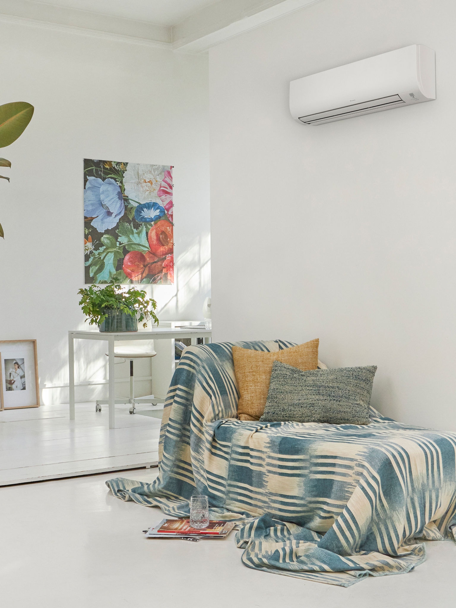 White living room with couch in it and a wall-mounted climate solution above it