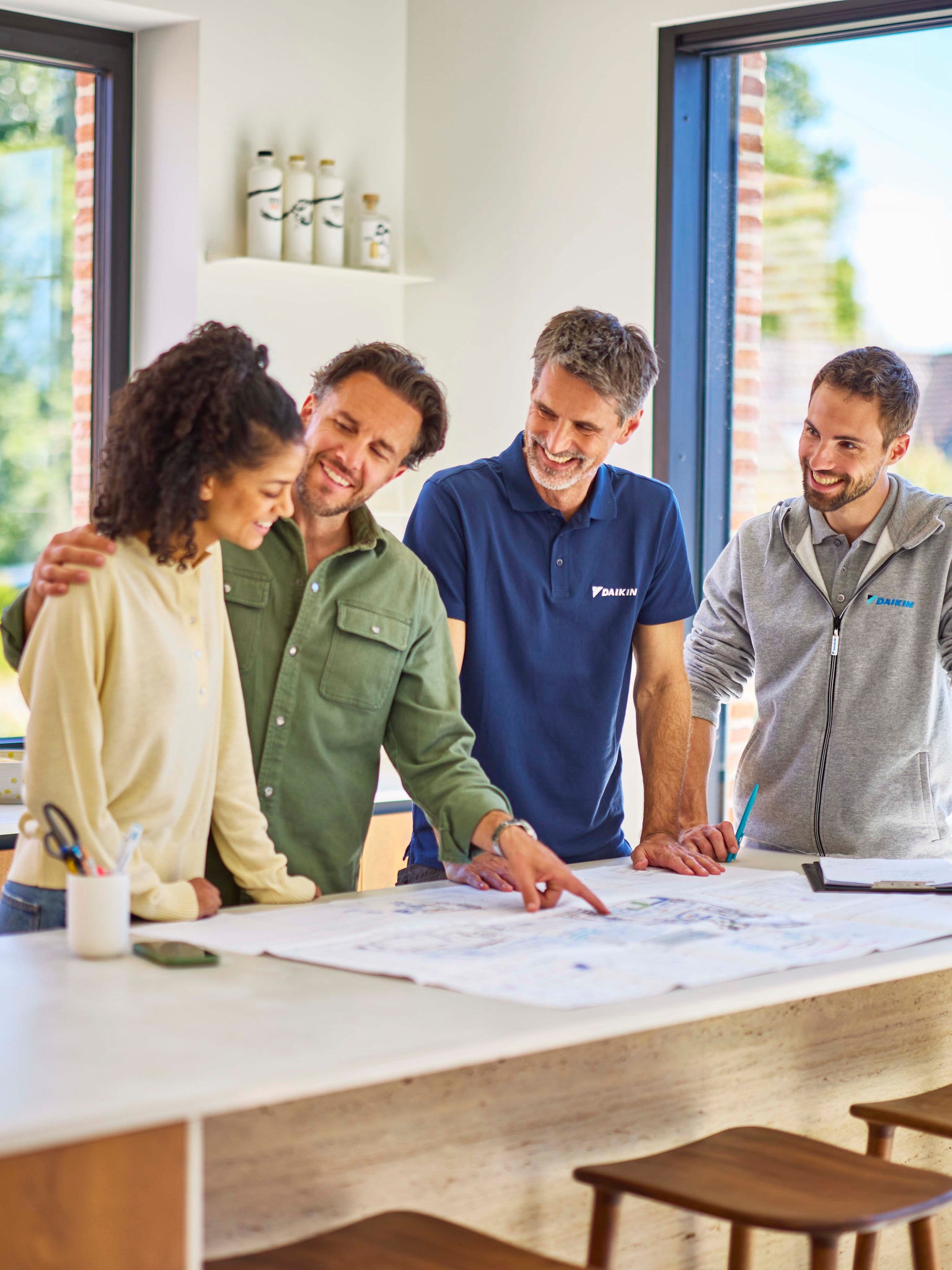 Homeowners reviewing renovation plans while choosing the right heat pump system