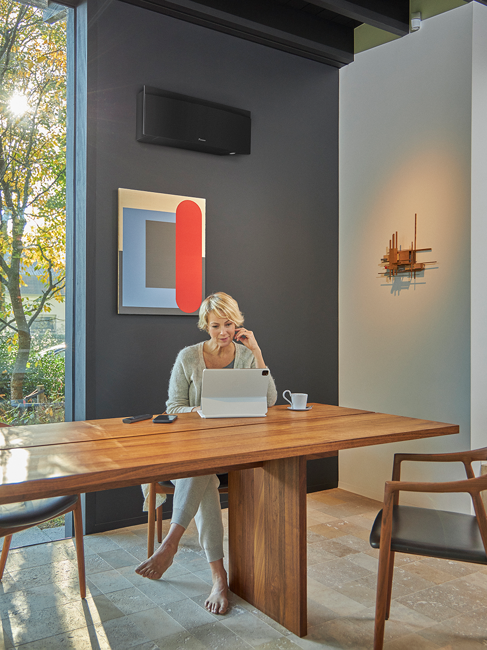 Lady sitting at desk with AC unit behind her