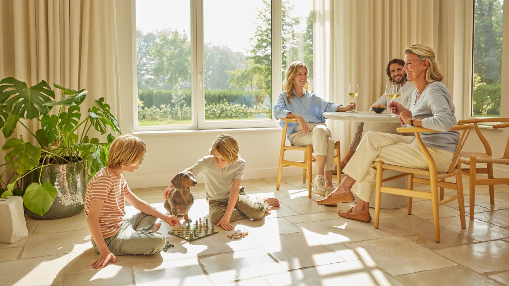 Family enjoying clean indoor air with Daikin air purifier, as children play chess and adults relax with drinks in a bright, well-ventilated living room