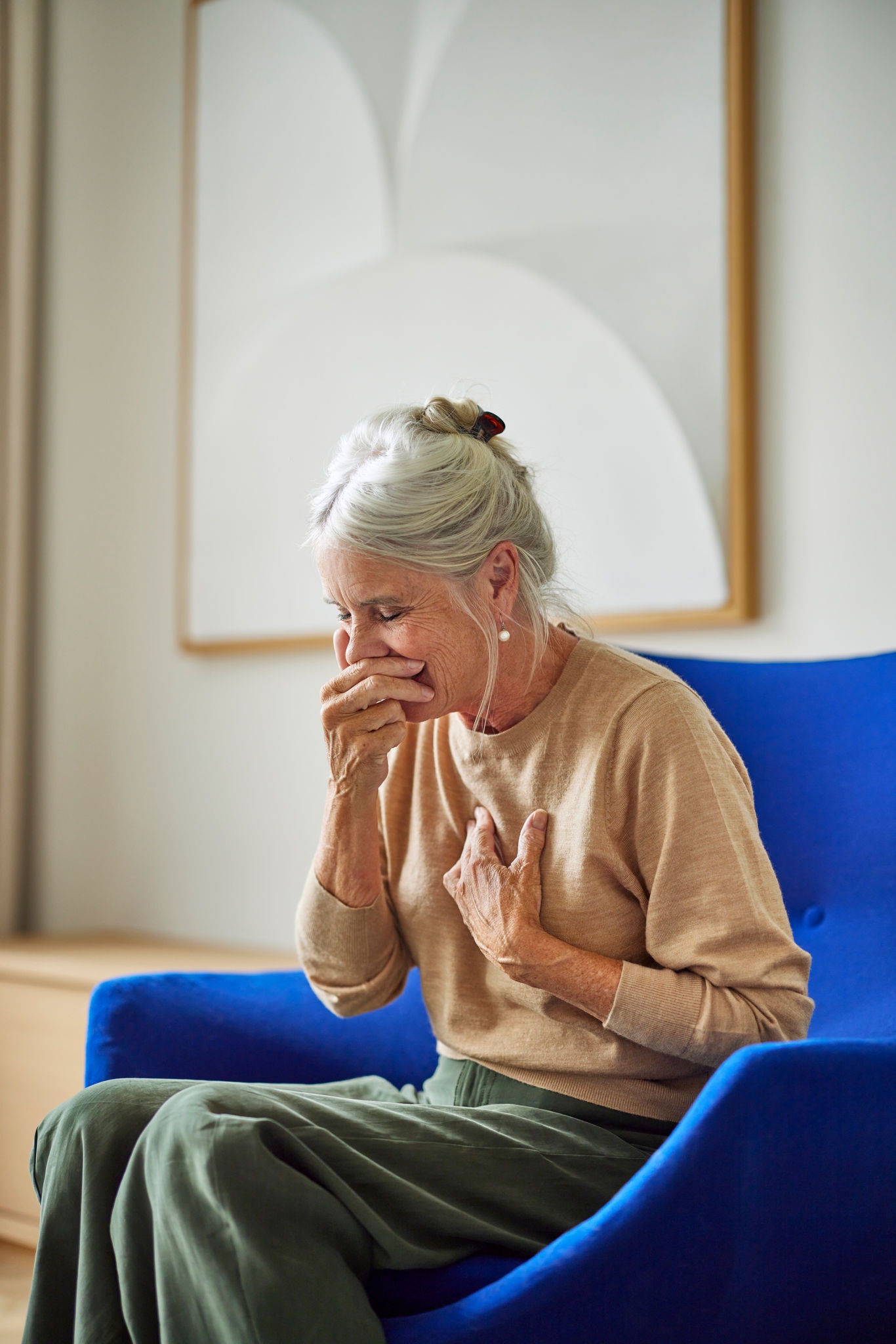 Woman sneezing, illustrating how ventilation supports better air quality and reduces asthma triggers