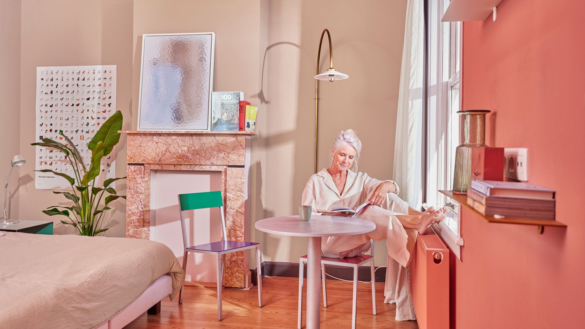 Older woman enjoying low-temperature radiator in cozy bedroom with heat pump