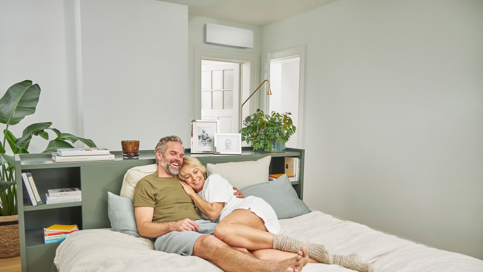 Couple relaxing on a bed in a cool bedroom with quiet air conditioning