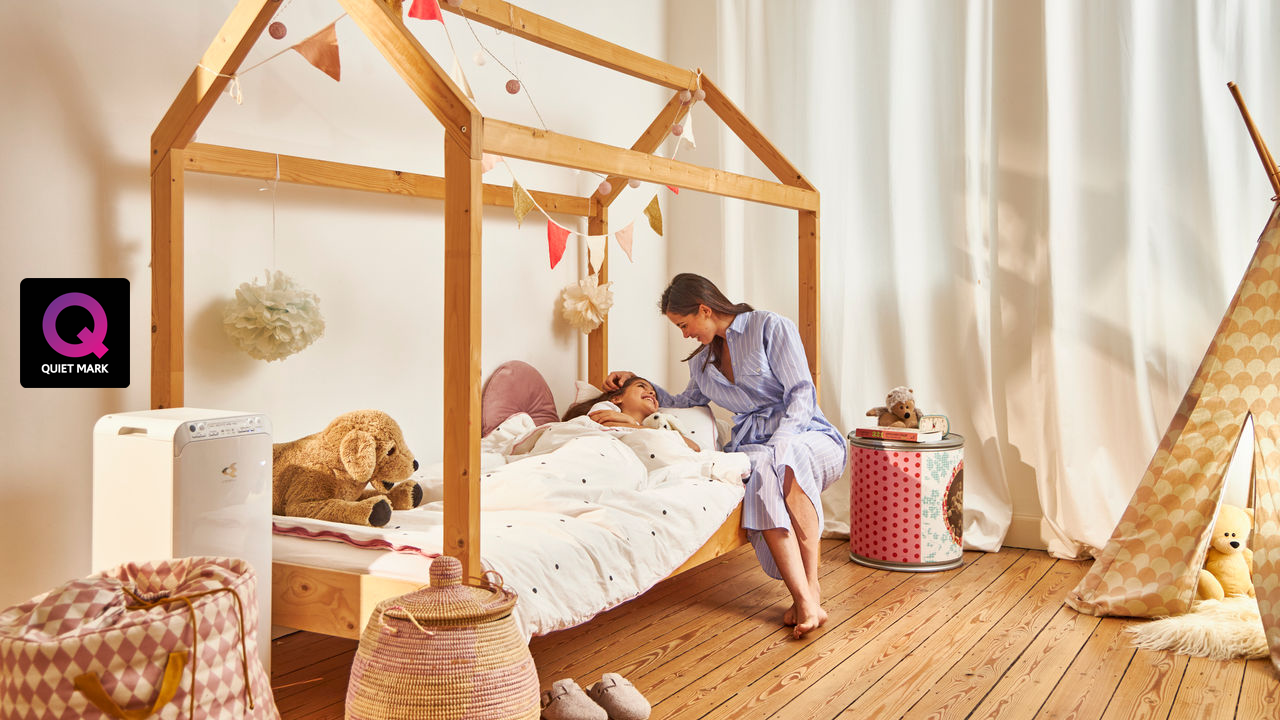 Mother putting child to bed in their healthy home thanks to the Daikin air purifier in the children's room