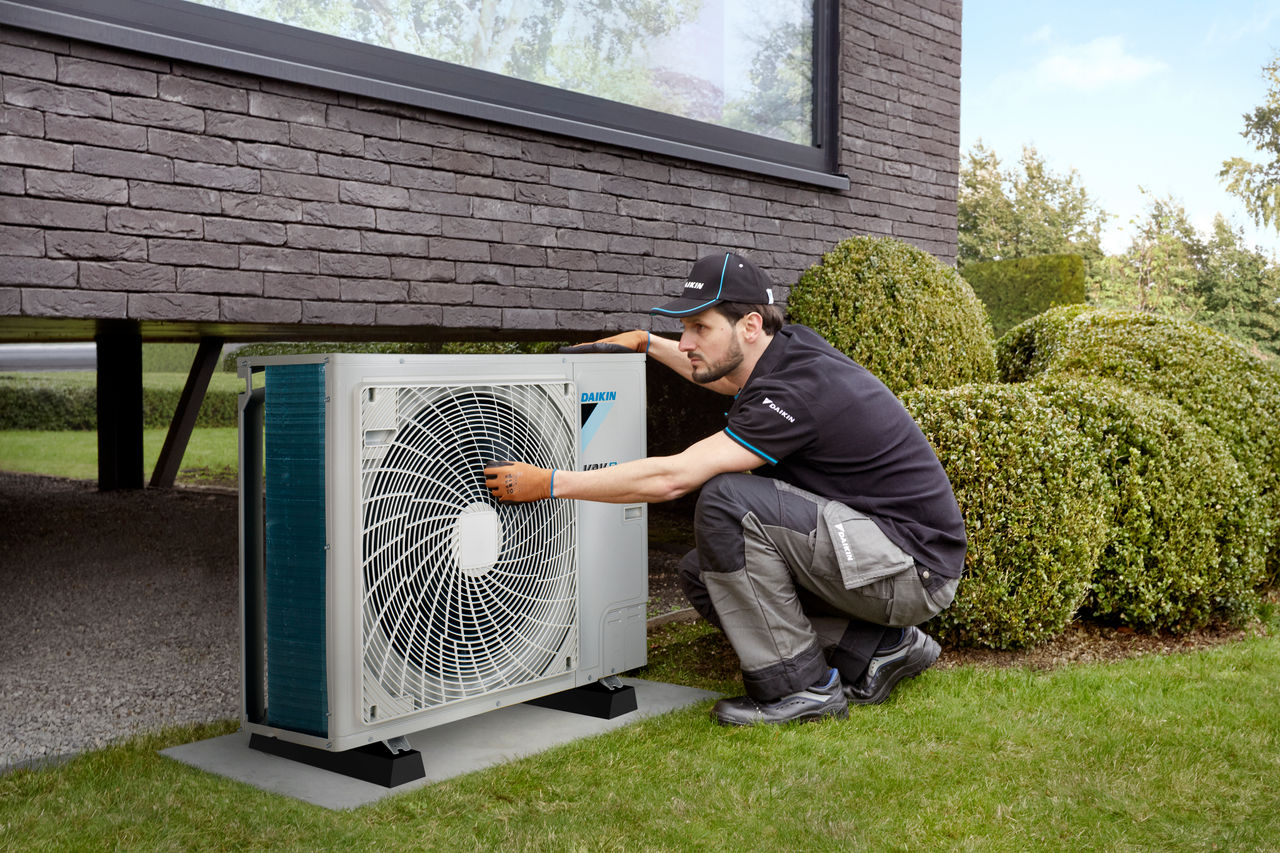 Engineer servicing Daikin heat pump